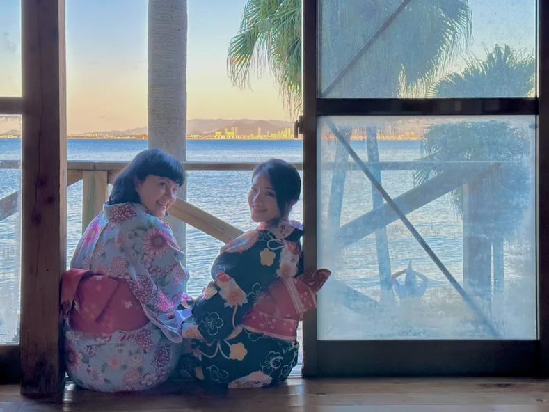 Dos chicas en una ventana con vestimenta tradicional japonesa en Fukuoka, Japón